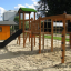 Cấu trúc leo trèo và cầu trượt Romping Cottage bằng gỗ cho khu vui chơi trẻ em.