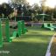 Thiết bị tập thể dục ngoài trời màu xanh lá cây Ribbon Fitness I trên mặt cỏ nhân tạo.