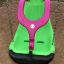 Ghế xích đu All Access Seat màu xanh lá với khung bảo vệ màu hồng, phù hợp cho trẻ em.