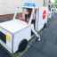 Xe chơi trẻ em mô hình Ambulance màu trắng với bánh xe đen và đèn báo hiệu màu xanh.