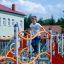 Ursa Maior castle with slide, climbing net với các thanh leo màu cam và lưới dây xanh, có trẻ em chơ
