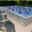 Football Table Game với tay cầm đen và các quân chơi màu đỏ và xanh trên bàn đá granite.