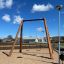 Xích đu Nature Double Swing 5m bằng gỗ với hai ghế ngồi trên sân chơi ngoài trời.
