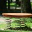 Wooden Balance Board với mặt gỗ tròn và chân lò xo cho sân chơi trẻ em.