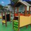 Khu vui chơi Omega Accessible Playground với cấu trúc gỗ và bảng trò chơi tương tác màu xanh lá.
