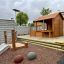 Nhà chơi gỗ Wooden Garden Playhouse w/ Fencing với hàng rào và khu vực vui chơi an toàn cho trẻ em.