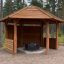 Wooden Wall to Gazebo Shelter bằng gỗ với mái che hình lục giác và tường chắn một phần.