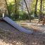 Cầu trượt Hill Slide h150 bằng kim loại gắn trên đồi nhỏ trong sân chơi trẻ em.