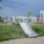 Cầu trượt Hill Slide Wide h120 bằng kim loại gắn trên đồi cỏ cho khu vui chơi trẻ em.